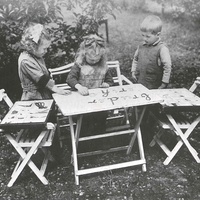 Lettere smerigliate Children in the garden of the Berlin-Lankwitz Children's House (1919-22) making words with the moveable alphabet. Consonants and vowels are in different colours. In the Children's House, three strong cardboard boxes and a folder with 354 cut-out letters of different coloured cardboard are available. The photograph was published in the Berliner Illustrirte Zeitung in 1927 - T. Müller, R. Schneider, <em>Lehrmaterialien 1913-1935. Möbel und Architektur. Techning Meterials 1913-1935. Furniture and Architecture</em>, München, Prestel Verlag, 2002, p.103$$$471