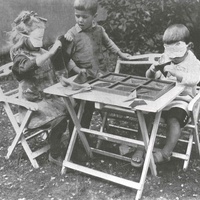 Lavori all'aperto Sensory exercises in the garden of the Children's House, Berlin-Lankwitz, 1919-22. The girl on the left is feeling the different types of fabric; the boy on the right is feeling the shapes of the inset figures from the geometry cabinet. He runs his index and middle finger around the figures in order to feel their shape without looking - T. Müller, R. Schneider,<em> Lehrmaterialien 1913-1935. Möbel und Architektur. Techning Meterials 1913-1935. Furniture and Architecture</em>, München, Prestel Verlag, 2002, p.97$$$461
