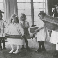 Casa dei bambini, U.S.A. Children in an American Children's House carrying the material they have chosen to their tales. The girl on the right is holding the "geometry cabinet." Photo: McClure, New York, 1912. The geometry cabinet has six drawers and holds 32 different geometrical insets: squares, circles, triangles and polygons of wood. The set also includes a frame into which six figures can be inserted. The child learns to recognise the different shapes both visually and through touch - T. Müller, R. Schneider, <em>Lehrmaterialien 1913-1935. Möbel und Architektur. Techning Meterials 1913-1935. Furniture and Architecture</em>, München, Prestel Verlag, 2002, p.96$$$460